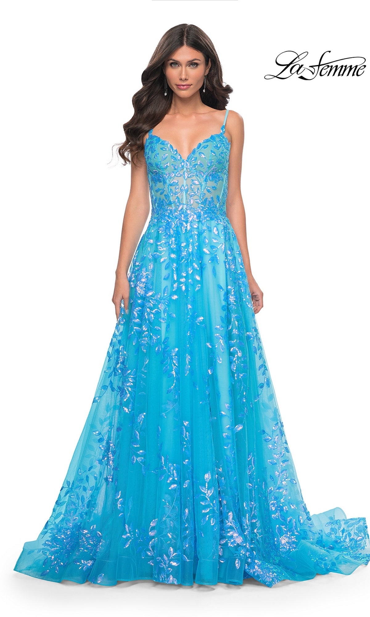 A woman wearing the La Femme Sequin-Print Long A-Line Prom Dress 32223 in bright blue with floral sequin details and thin straps, standing against a plain white background.